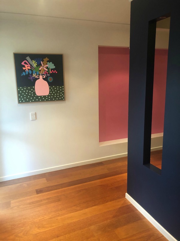 Hallway with navy and pink walls and Hayley Wills painting