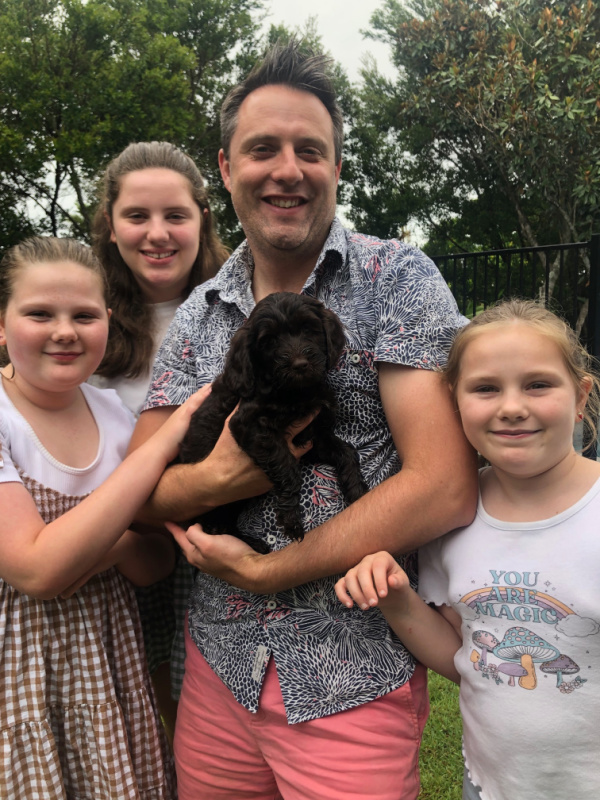 Family holding Labradoodle puppy